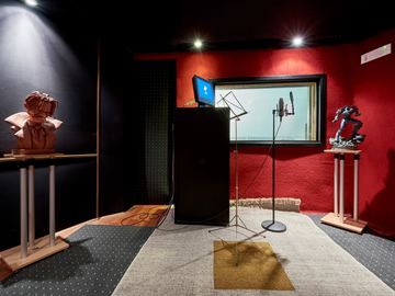 Sound recording booth with microphone and isolation window
